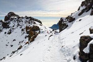 Guiden vækker dig kl. 23:30 (dag 06) og byder på te og lidt snacks, inden vi bevæger os op mod toppen.   På vej mod Hans Meyer Cave er stien meget stenet. Når vi når Hans Meyer Cave, fortsætter vi mod Gillman’s point. Vi befinder os nu i en højde af 5681 meter.  At nå til dette punkt er en enorm præstation, da vejen både er stejl og stenet.  Gillman’s point ligger i kraterranden, og herfra vil du ofte opleve, at stien mod toppen, Uhuru Peak, er dækket af sne.    Vi ankommer til Uhuru Peak – toppen af Kilimanjaro og 5895 meter i højden.  Du får tid til at tage nogle billeder og nyde en kop te, inden vi bevæger og nedad mod Horombi Hut igen.    Vi starter med at gå til Kibo Hut, hvilket tager ca. 3 timer.   Her hviler vi og nyder en frokost, inden vi bevæger os til Horombu Hut, hvor vi spiser aftensmad, vasker os og overnatter. 